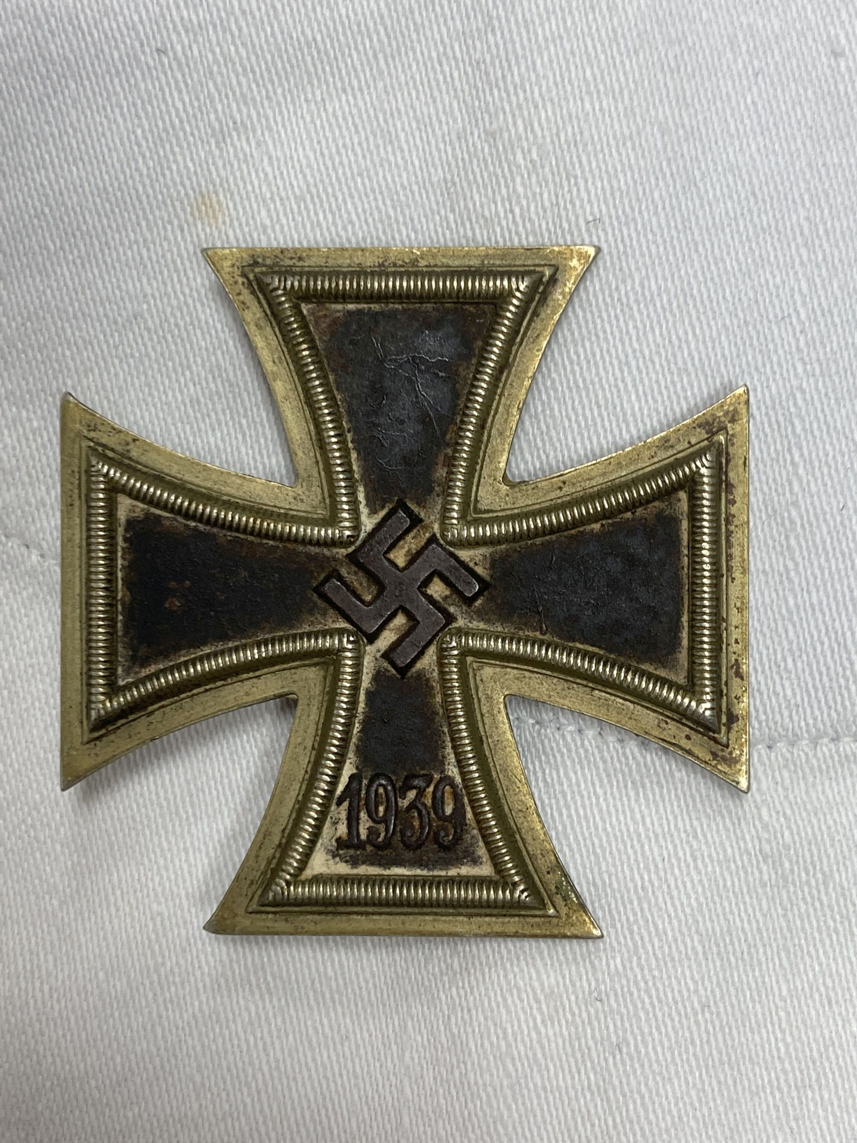 Two German Third Reich period white naval tunics, one named Schmidt. R, X176 T, together with an associated 1939 iron cross (3)